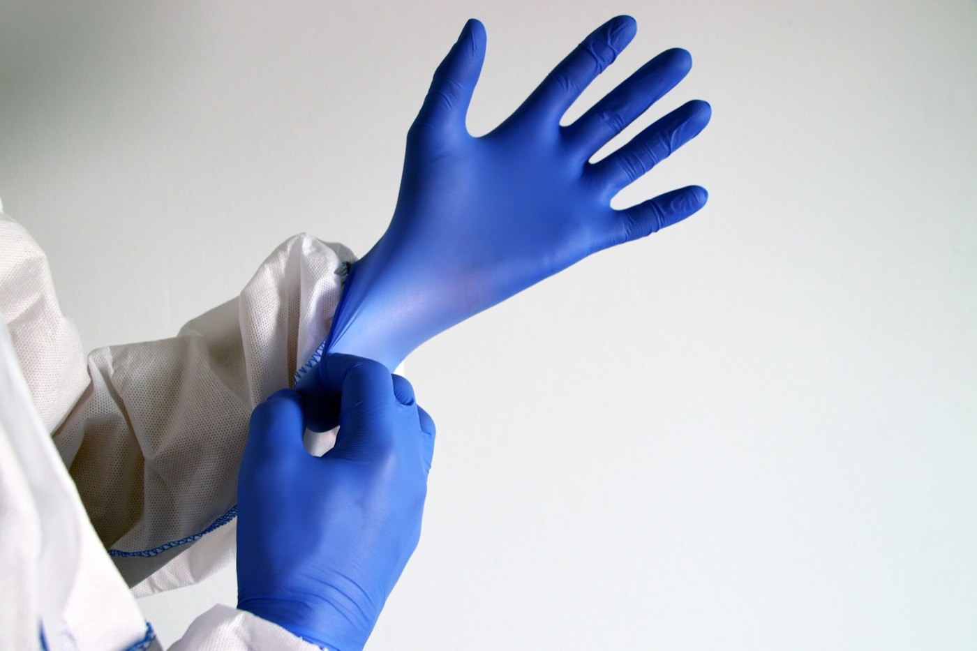 Fachkraft zieht im Reinraum sterile Handschuhe an